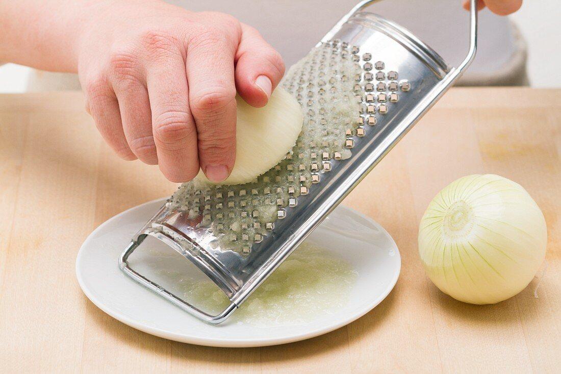Close-up shot of squeezing grated onion in a kitchen towel