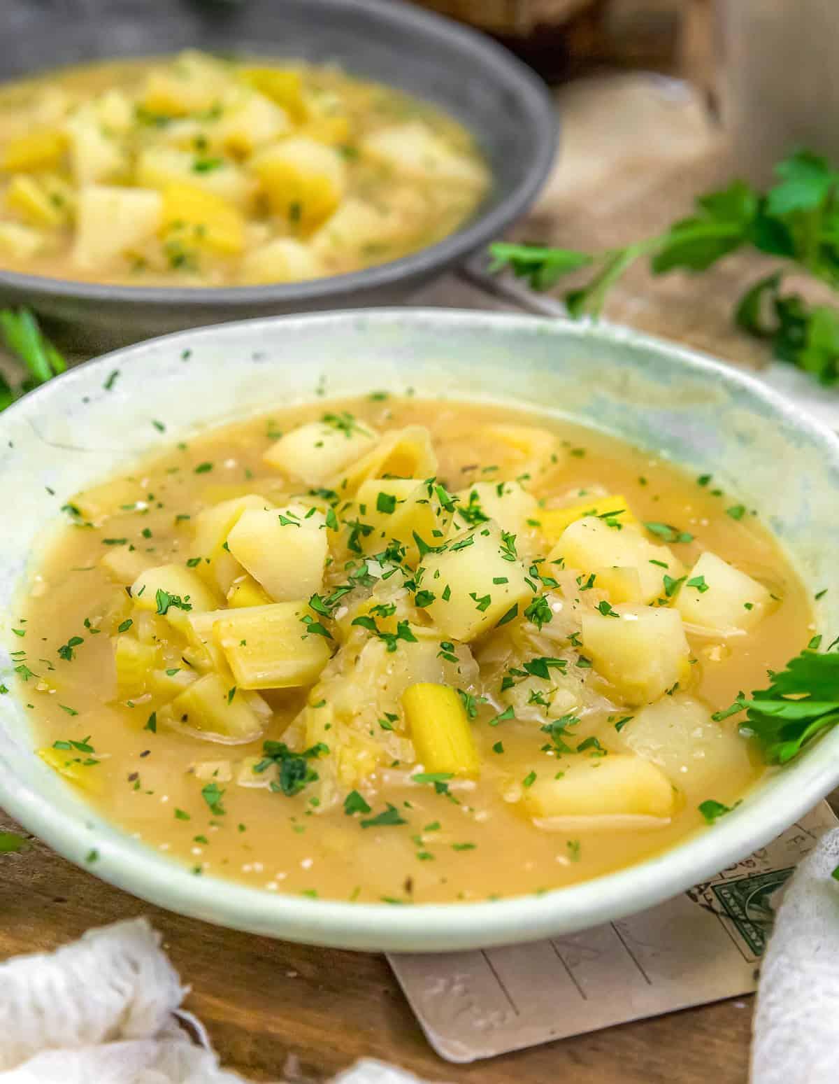 Creamy potato leek soup with fresh chives in a rustic bowl