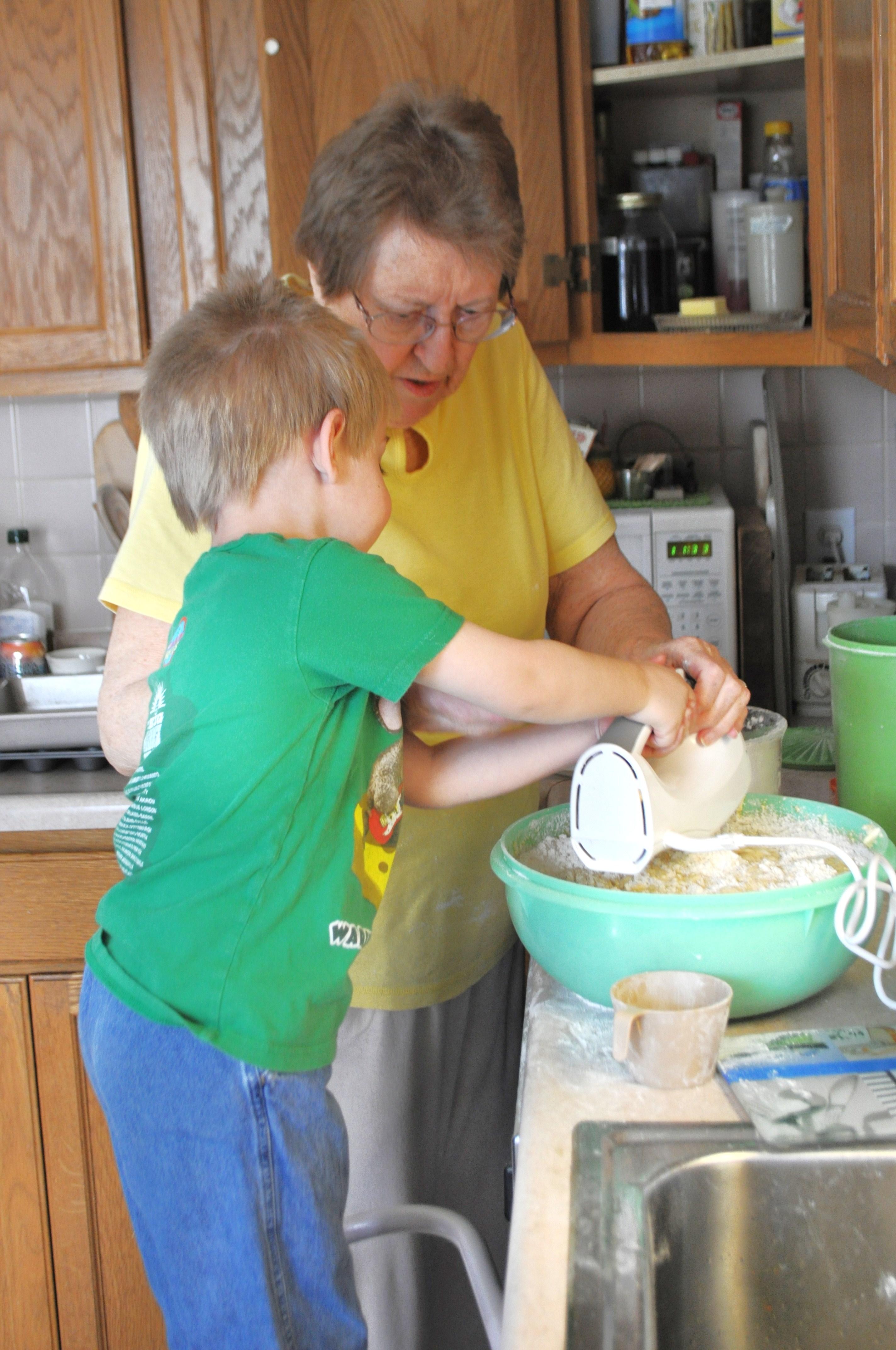 Grandmother and child baking banana bread in a sunlit kitchen