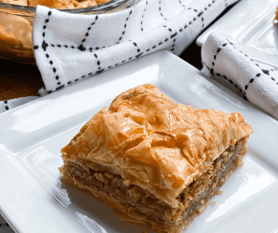 a slice of baklava bar being lifted from the pan, dripping with honey syrup