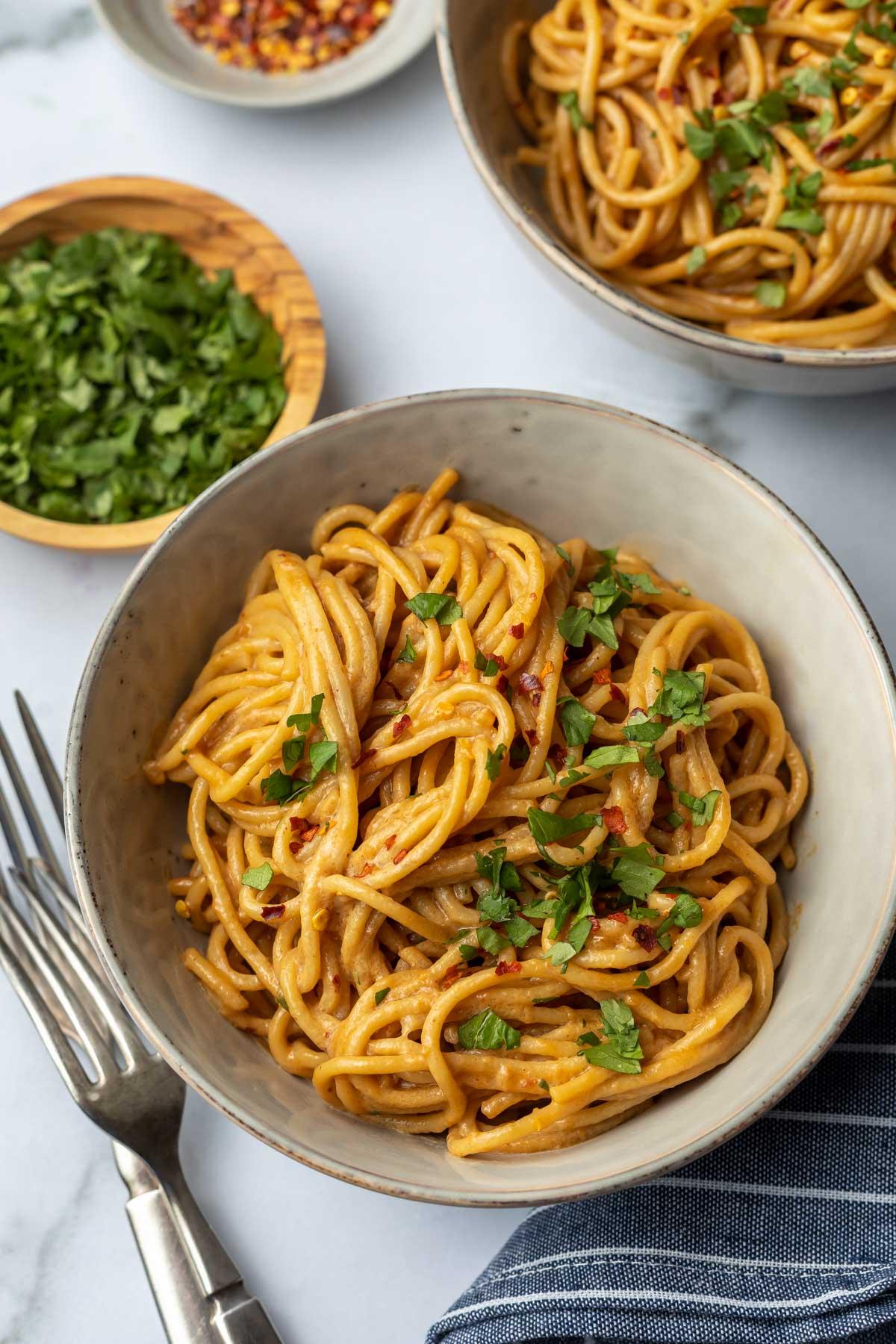 spicy peanut noodles garnished with cilantro and peanuts