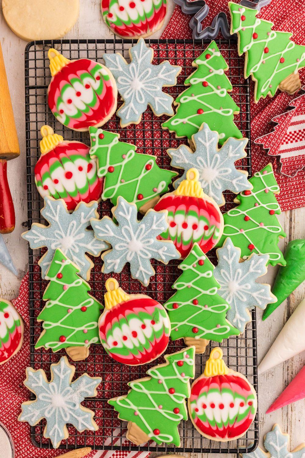 Assortment of beautifully decorated holiday sugar cookies with royal icing on a cooling rack