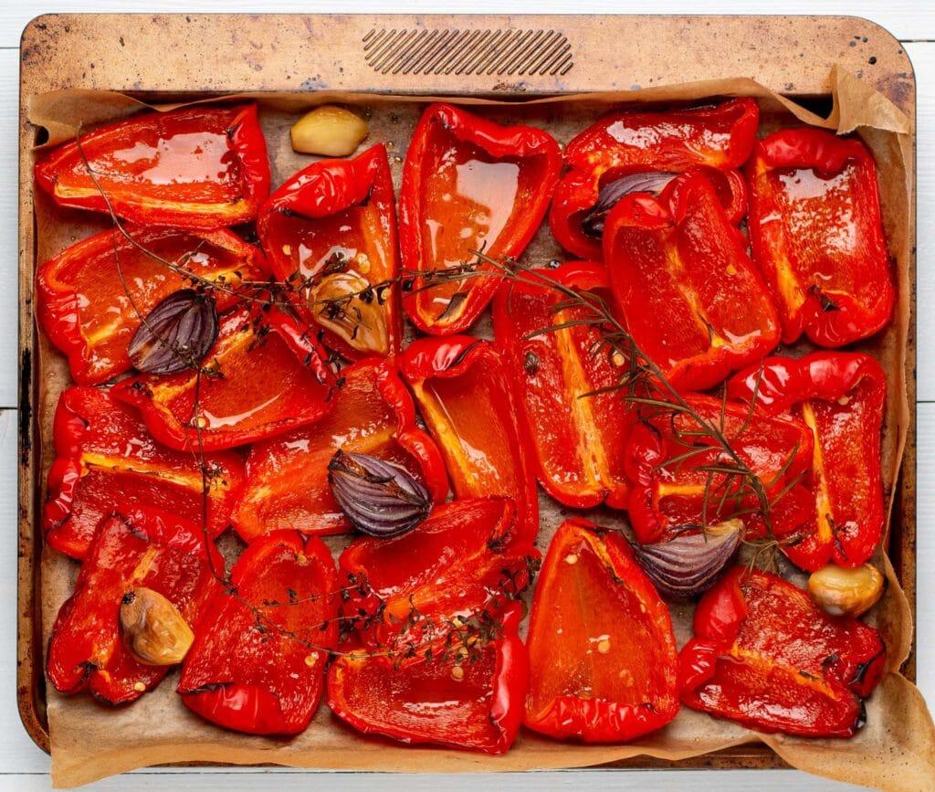 close-up of roasted red peppers and pumpkin on a baking sheet
