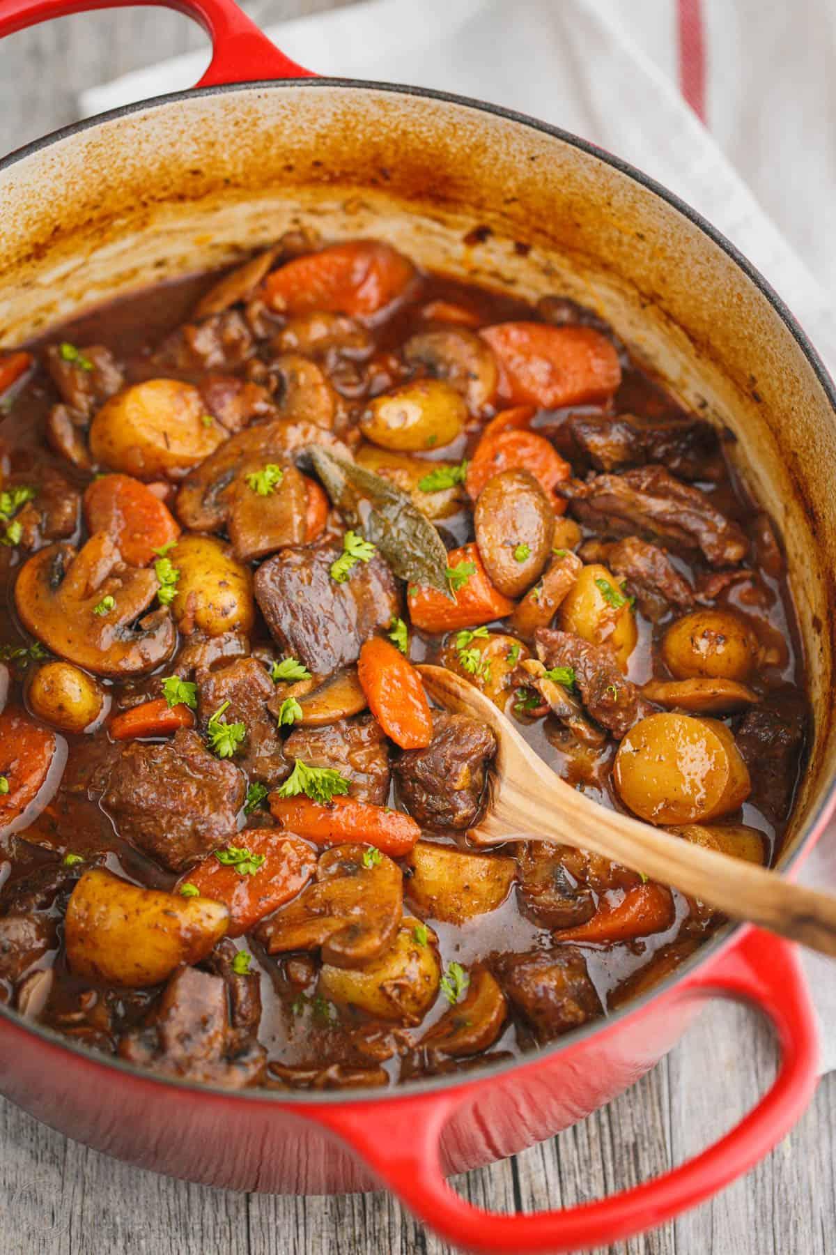 Cozy kitchen scene with chili garlic beef stew simmering on a stove, soft lighting