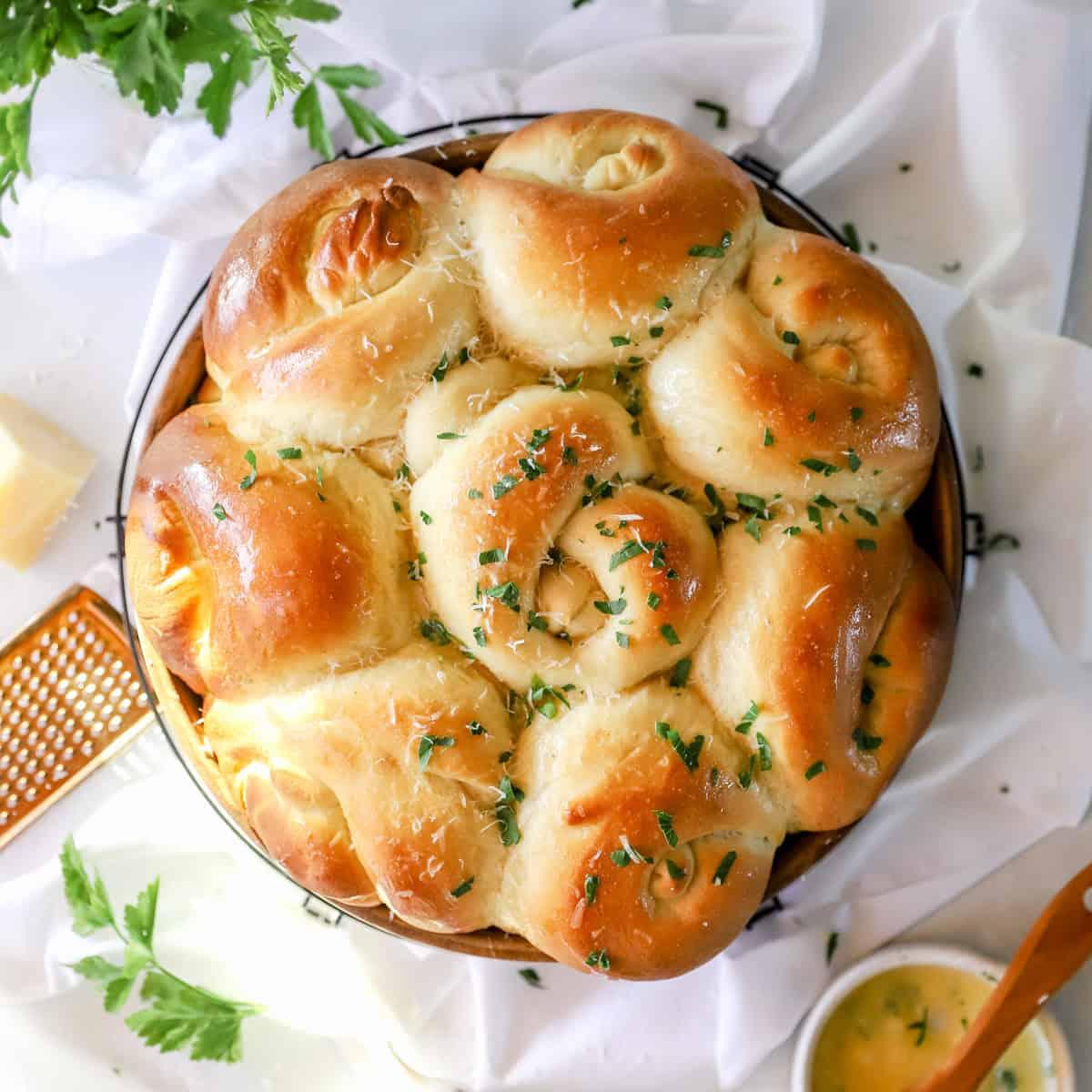 Close-up of golden brown parmesan garlic knots on a wire rack, steam gently rising