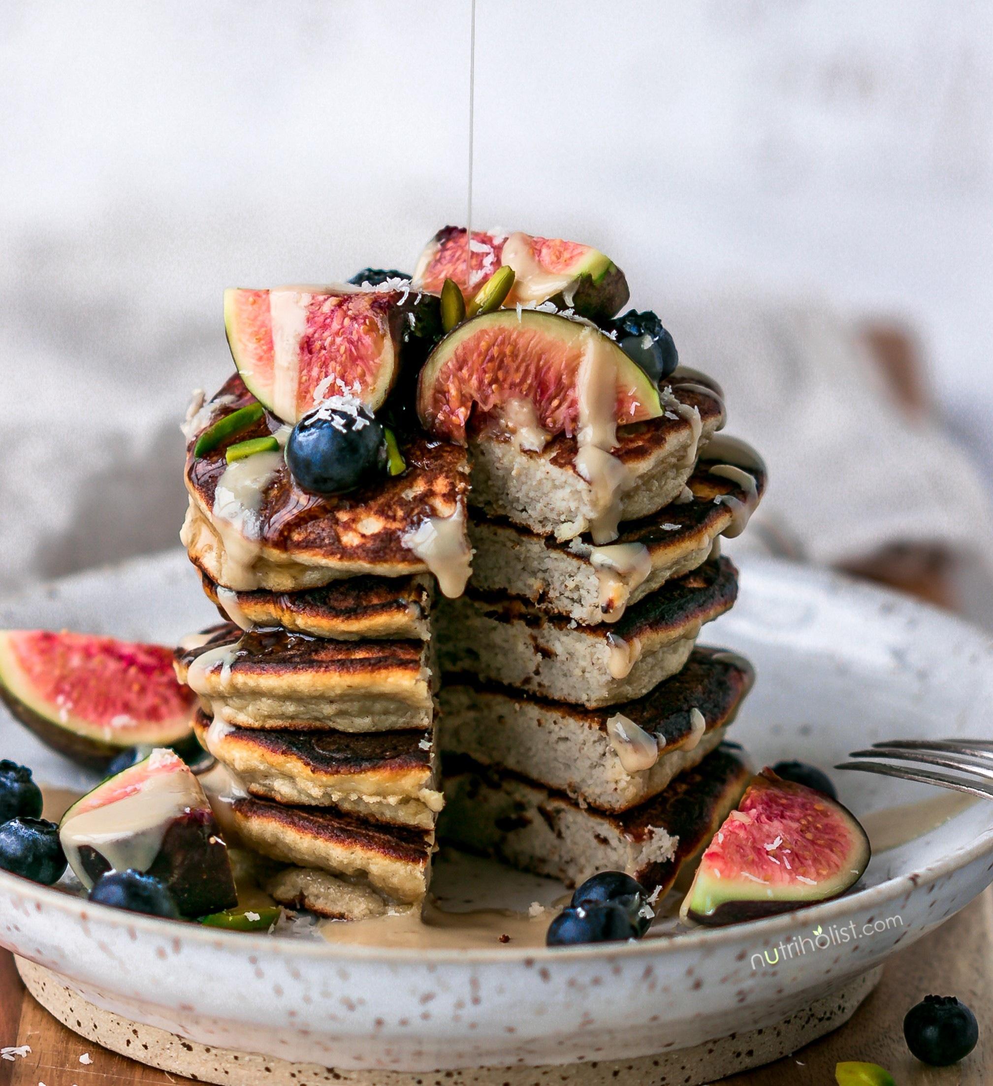 paleo breakfast with coconut flour pancakes topped with fresh berries and nuts