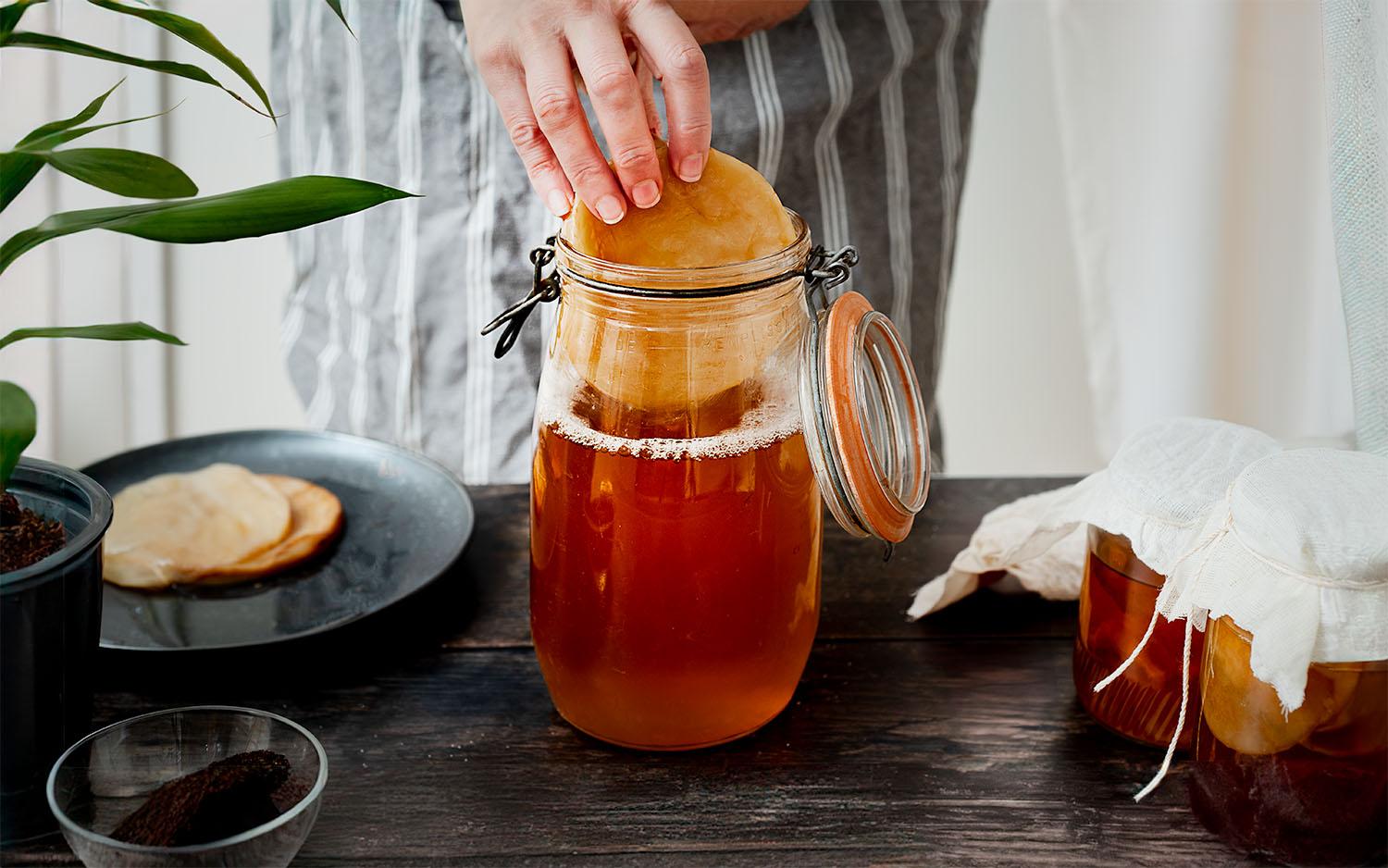 tangerine thyme kombucha being poured into a glass