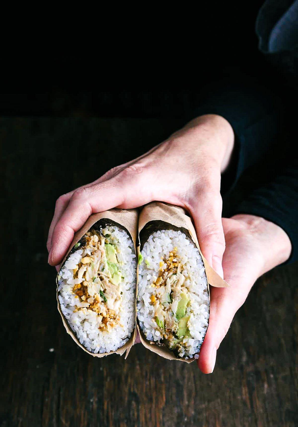 A person holding a completed Mediterranean Quinoa Sushi-Burrito