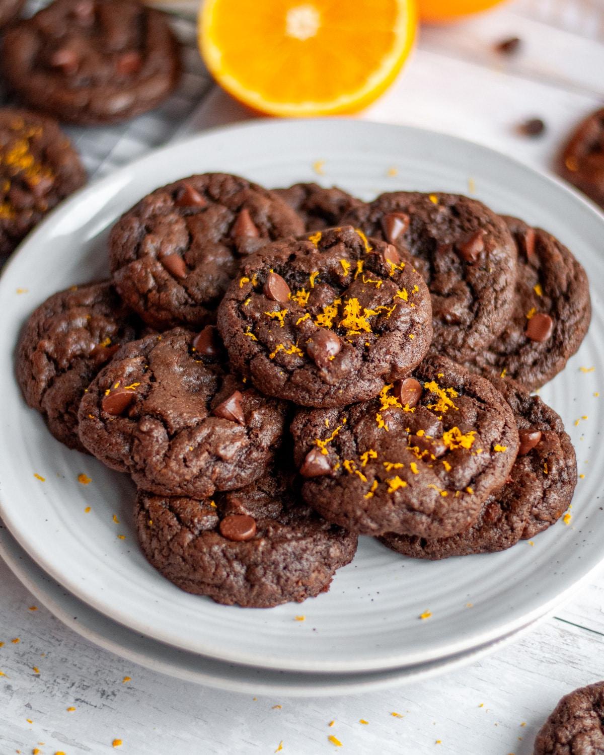 Shiny chocolate orange cookies on a cooling rack, vibrant orange zest