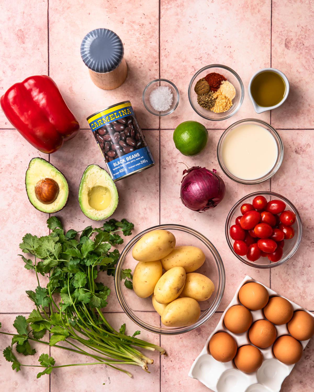 ingredients for southwest breakfast burrito bowl laid out on a wooden table