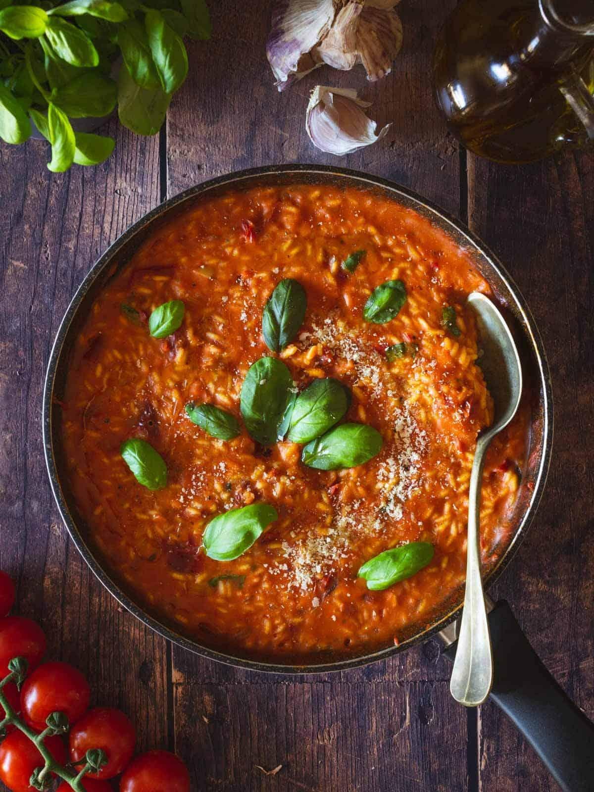 Close-up shot of sun-dried tomato and olive tapenade risotto being stirred in a pot