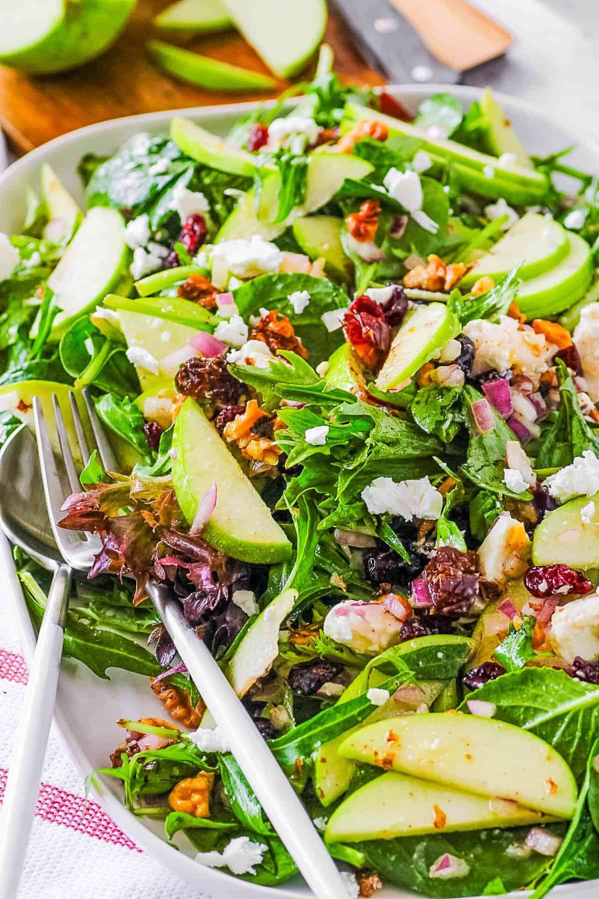 Apple walnut salad being served into individual bowls at a lunch gathering