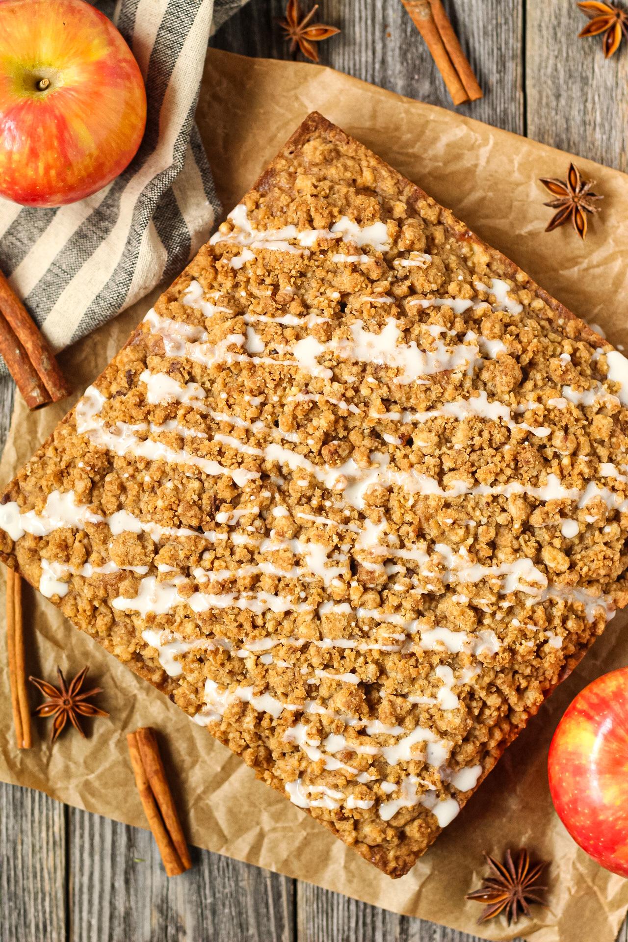 overhead shot of a cinnamon apple cake being sliced, with a visible moist crumb and chunks of apple