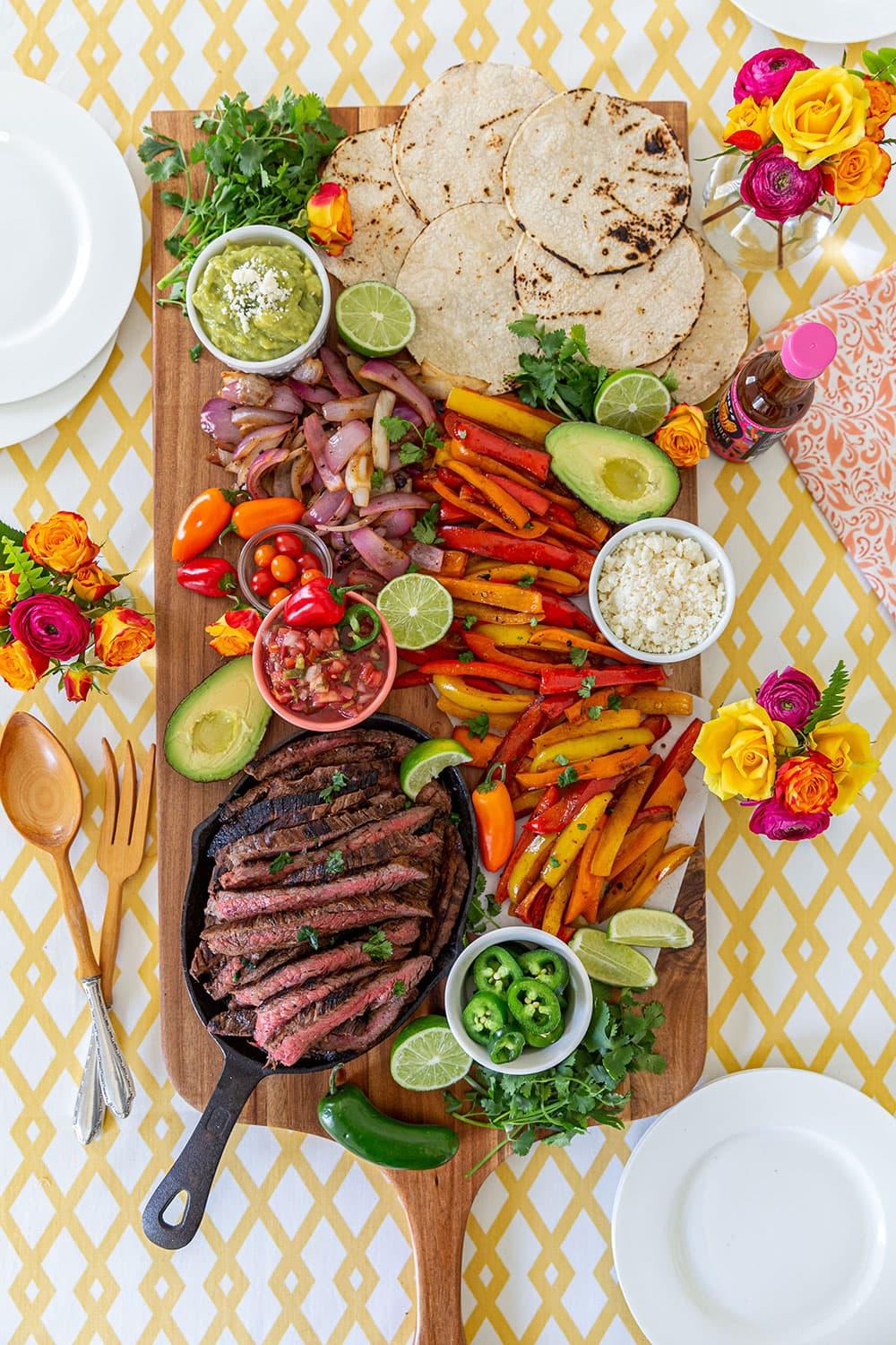 Beef fajita ingredients laid out on a wooden surface