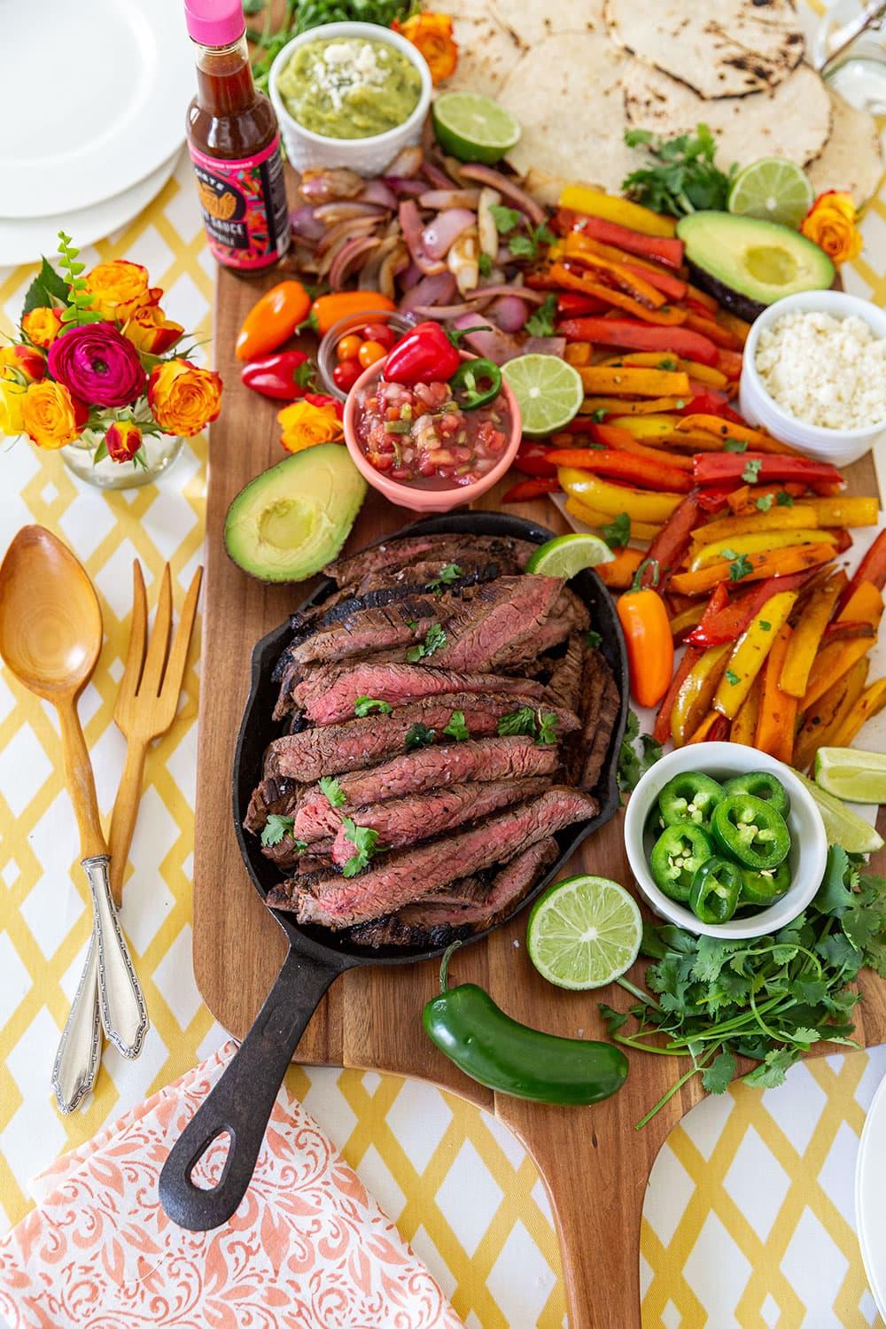 Sizzling steak and plantains fajitas on a rustic wooden board