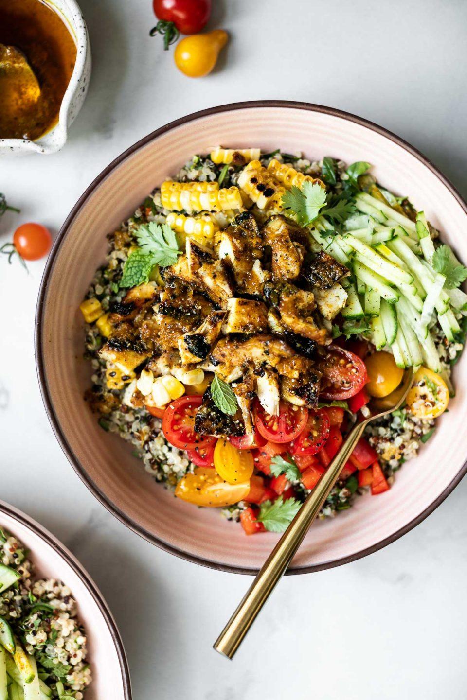Healthy chicken bowl with fresh herbs and quinoa, brightly lit