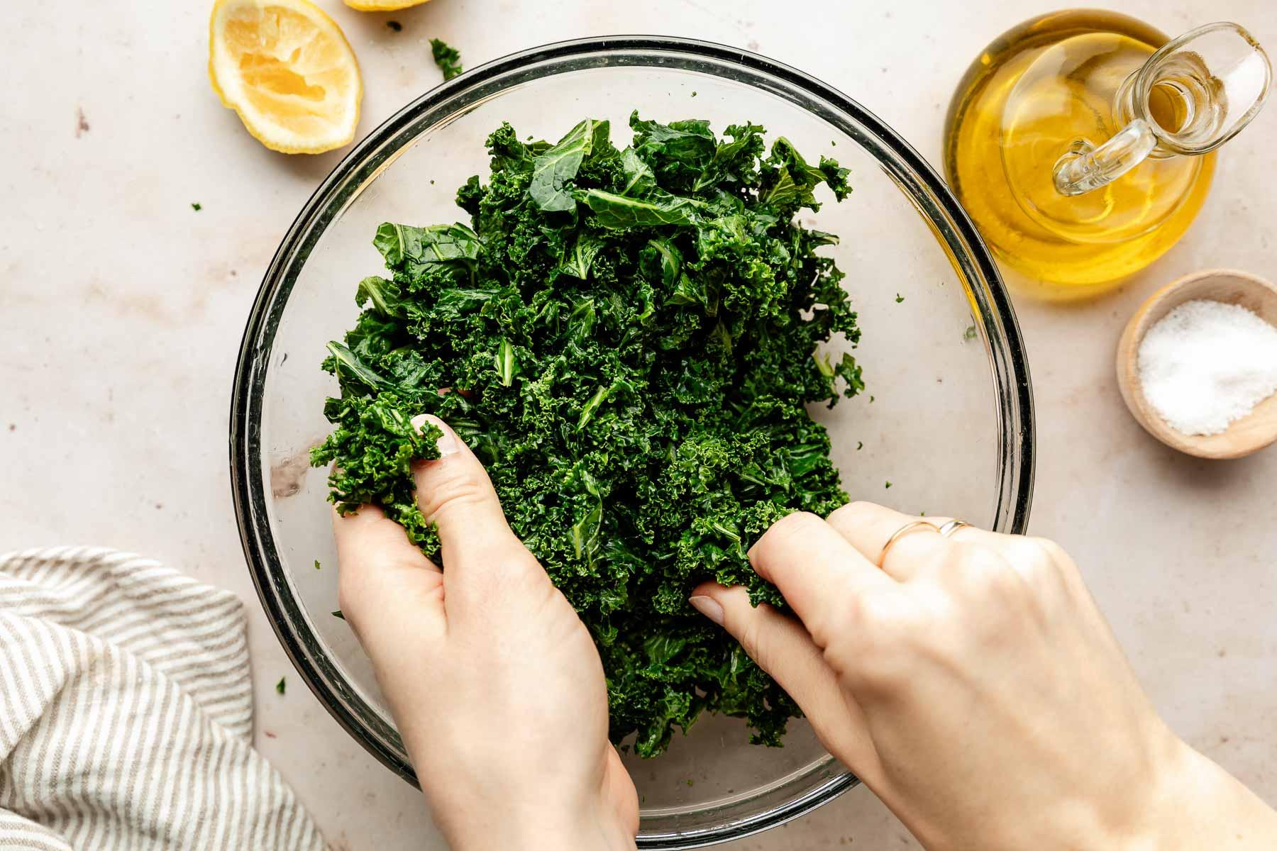 close up of massaging kale with olive oil