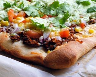 Close-up of Oklahoma Oasis Pizza with toppings like corn, black beans, and cilantro