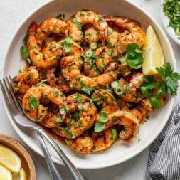 close up of uncooked shrimp being marinated in a lemon-garlic sauce