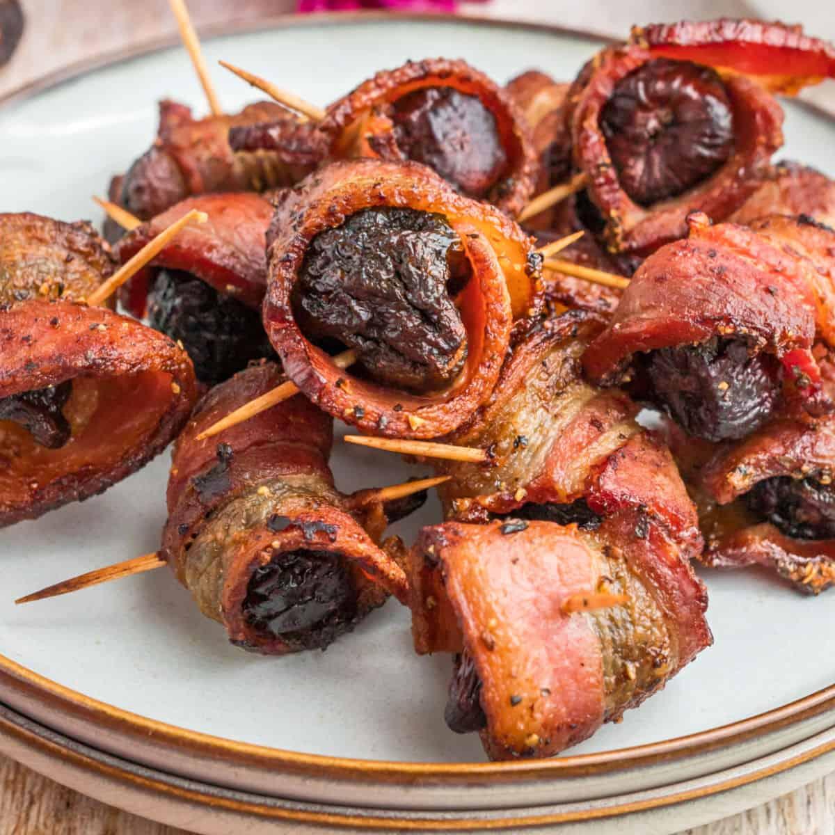 bacon wrapped figs with eggs florentine on a rustic wooden table