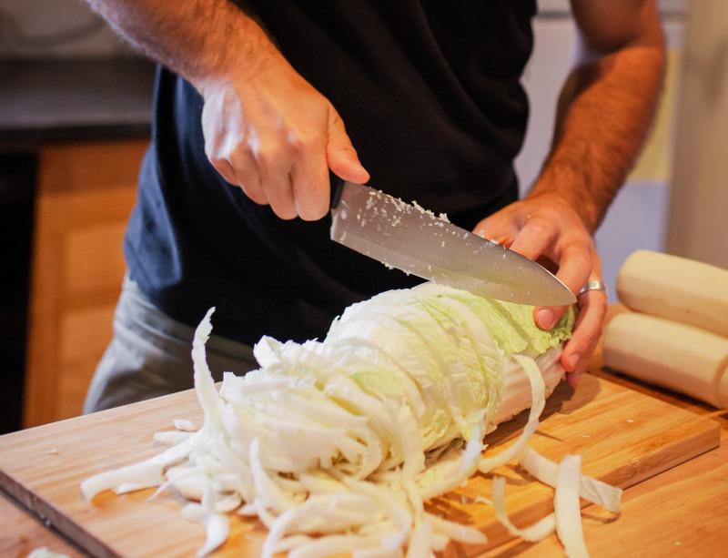 close up of kimchi being chopped on a cutting board