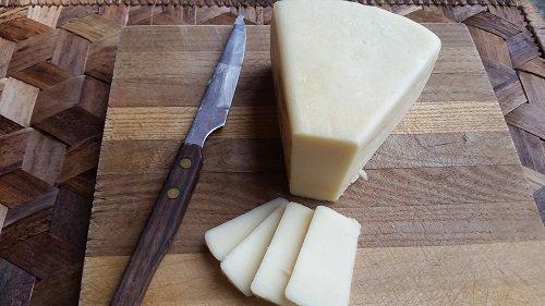 Close-up of alder smoked fontina cheese being sliced