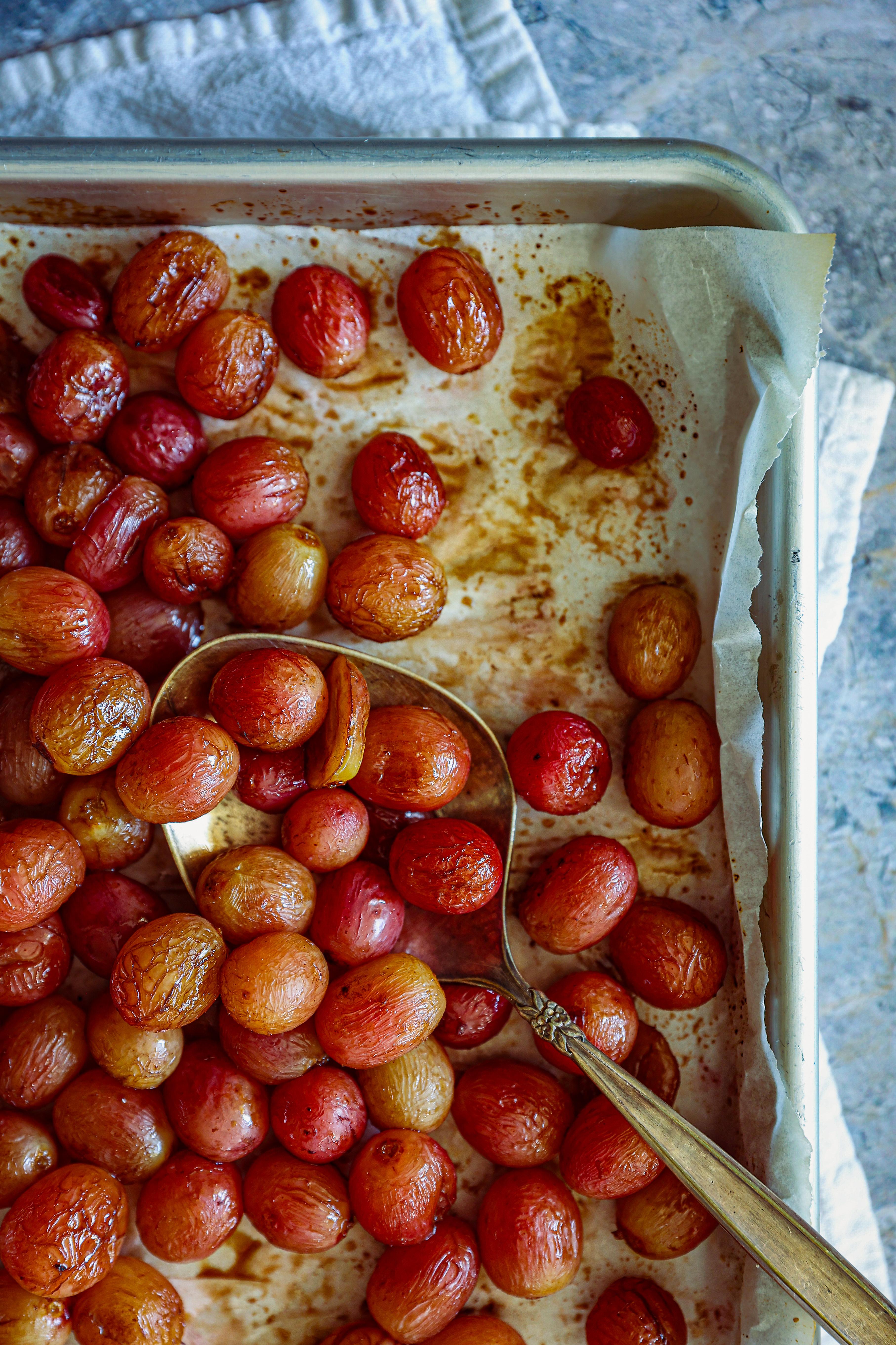 Close-up of roasted red grapes on a baking sheet