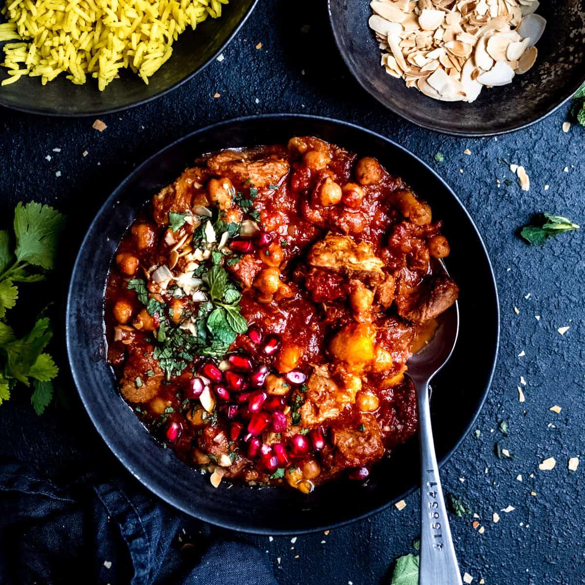Close-up shot of a vibrant, steaming Spicy Lamb Tagine with Chickpeas and Spinach in a rustic pot, garnished with fresh cilantro