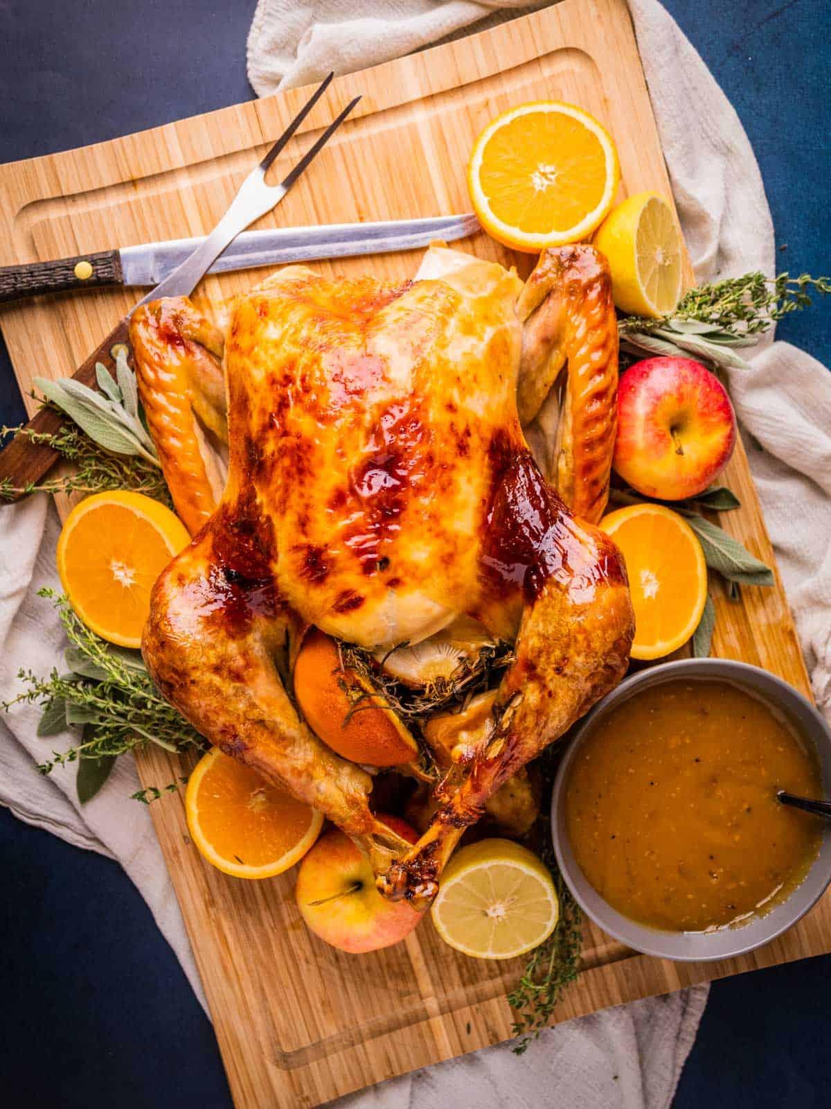 Close-up of golden brown turkey skin with glistening maple glaze and citrus slices