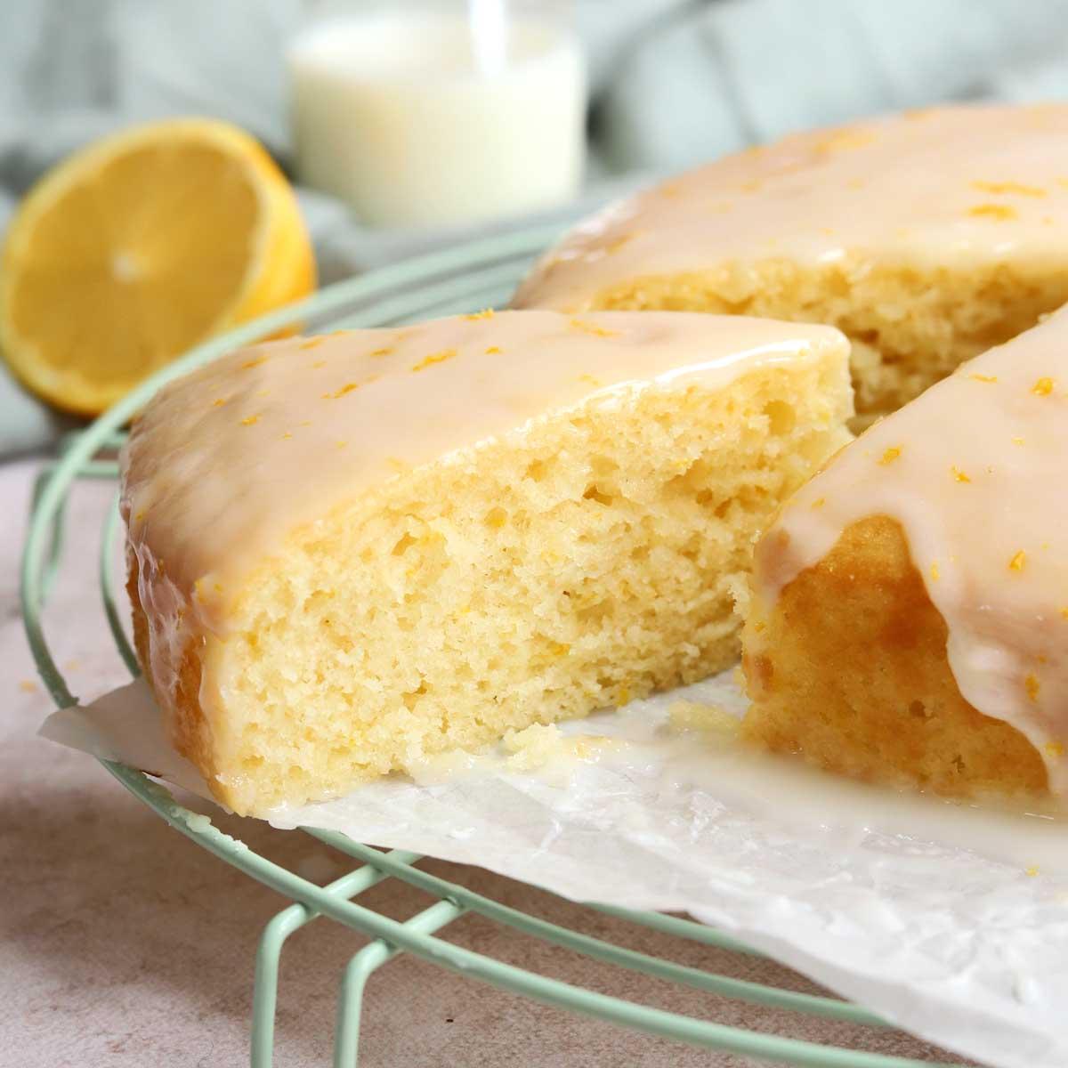 Bowl of lemon yogurt cake batter with fresh lemon zest being grated in, bright kitchen setting