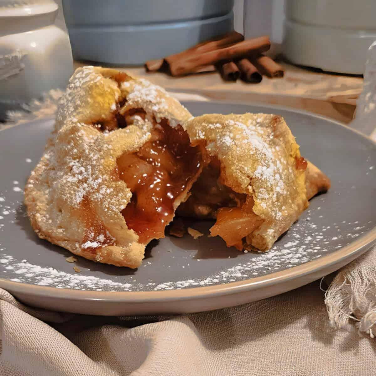golden brown apple pie empanadas on a baking sheet