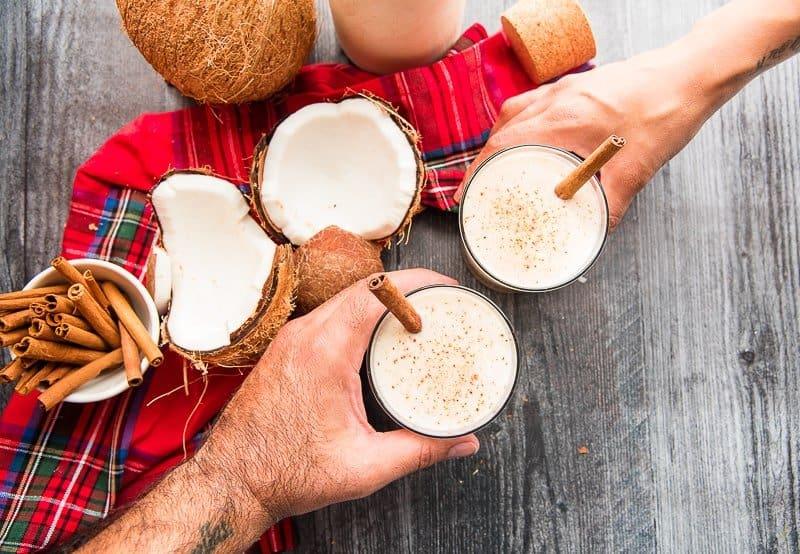 Joyful family gathered, holding glasses of Coquito, warm festive lighting