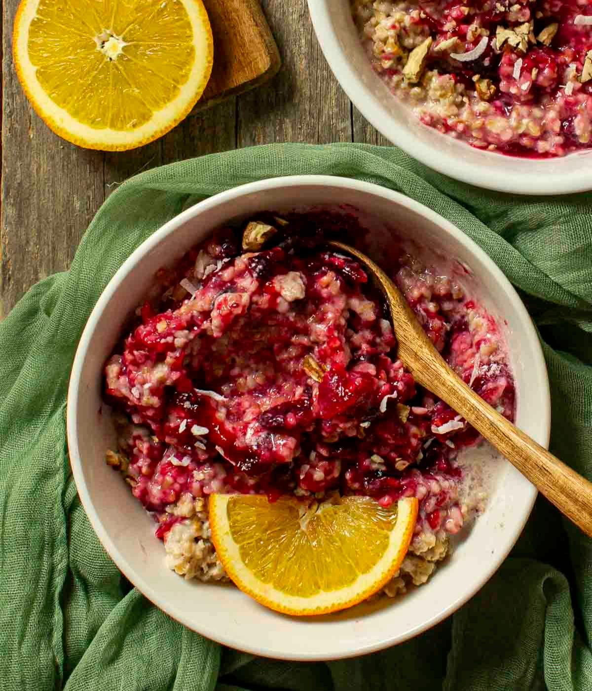 bowl of cranberry orange star anise oatmeal topped with nuts and orange zest