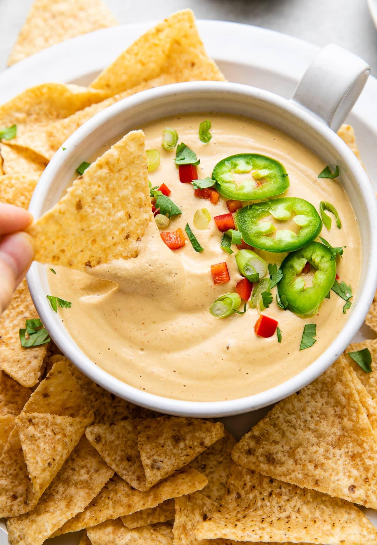 platter of cashew queso dip with various toppings and dippers