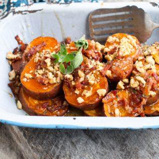 Sweet potato bites simmering in a maple glaze in a small saucepan