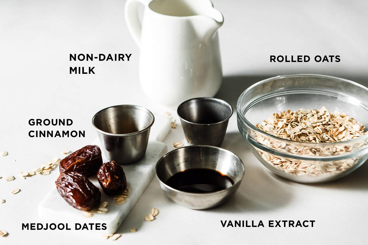 Ingredients for a date and cinnamon smoothie laid out on a wooden countertop.