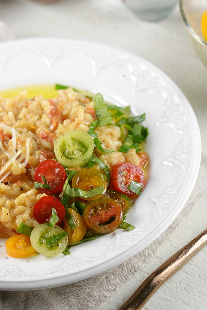 bowl of sun-dried tomato and olive risotto garnished with fresh basil