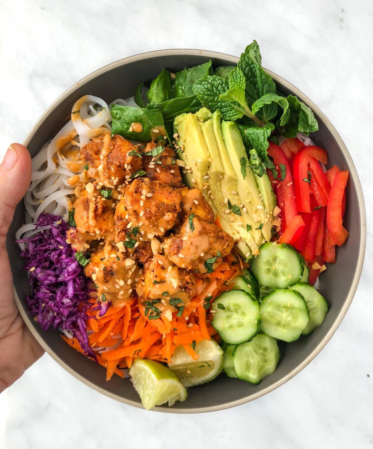 spicy peanut noodles with tofu wrap served in a bowl