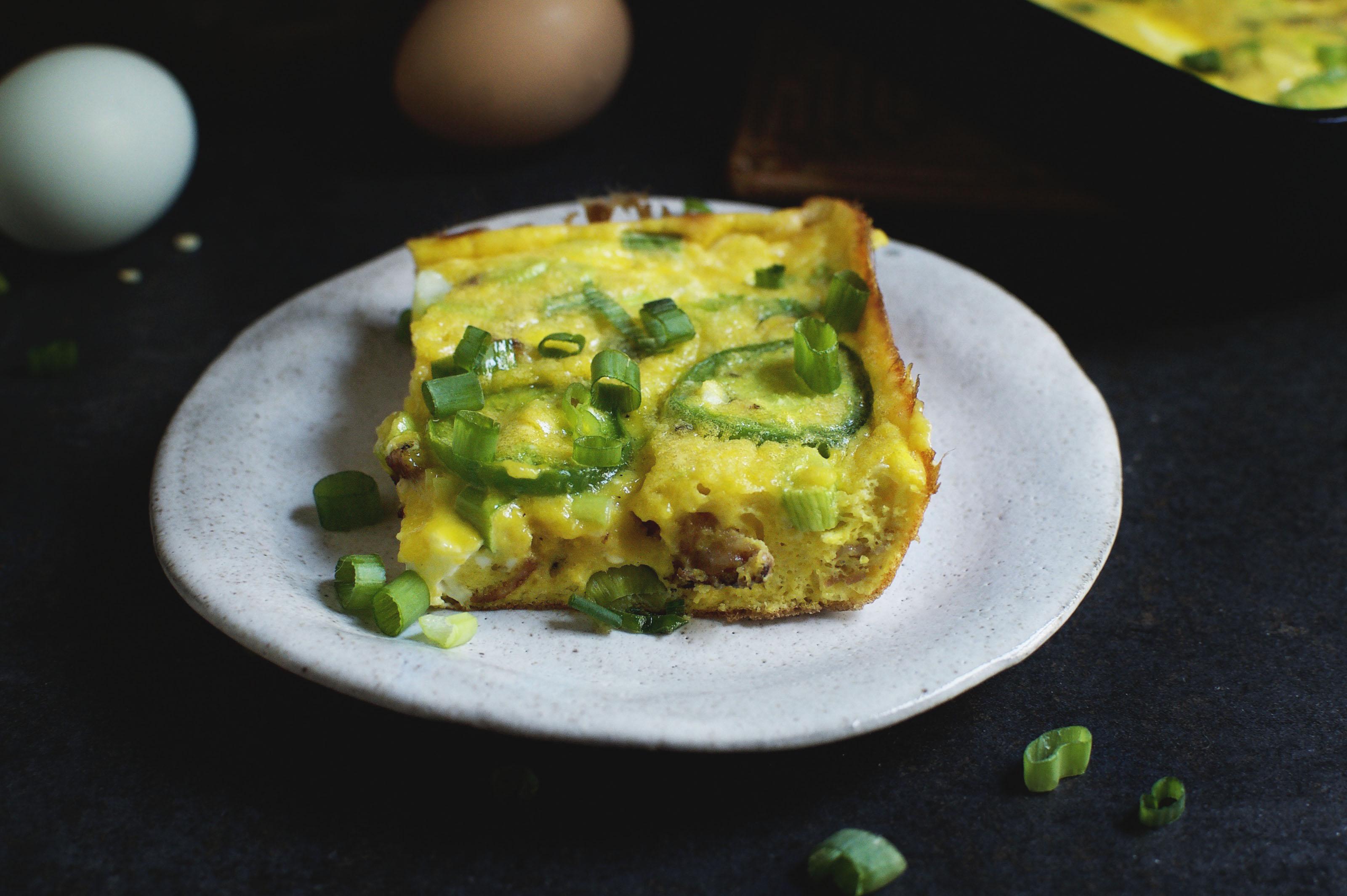 overhead shot of a slice of Jalapeño Popper Frittata on a plate with a fork