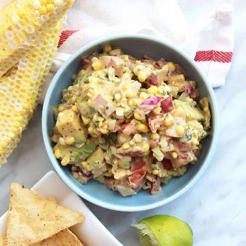 close up shot of fresh corn and avocado salsa with tortilla chips