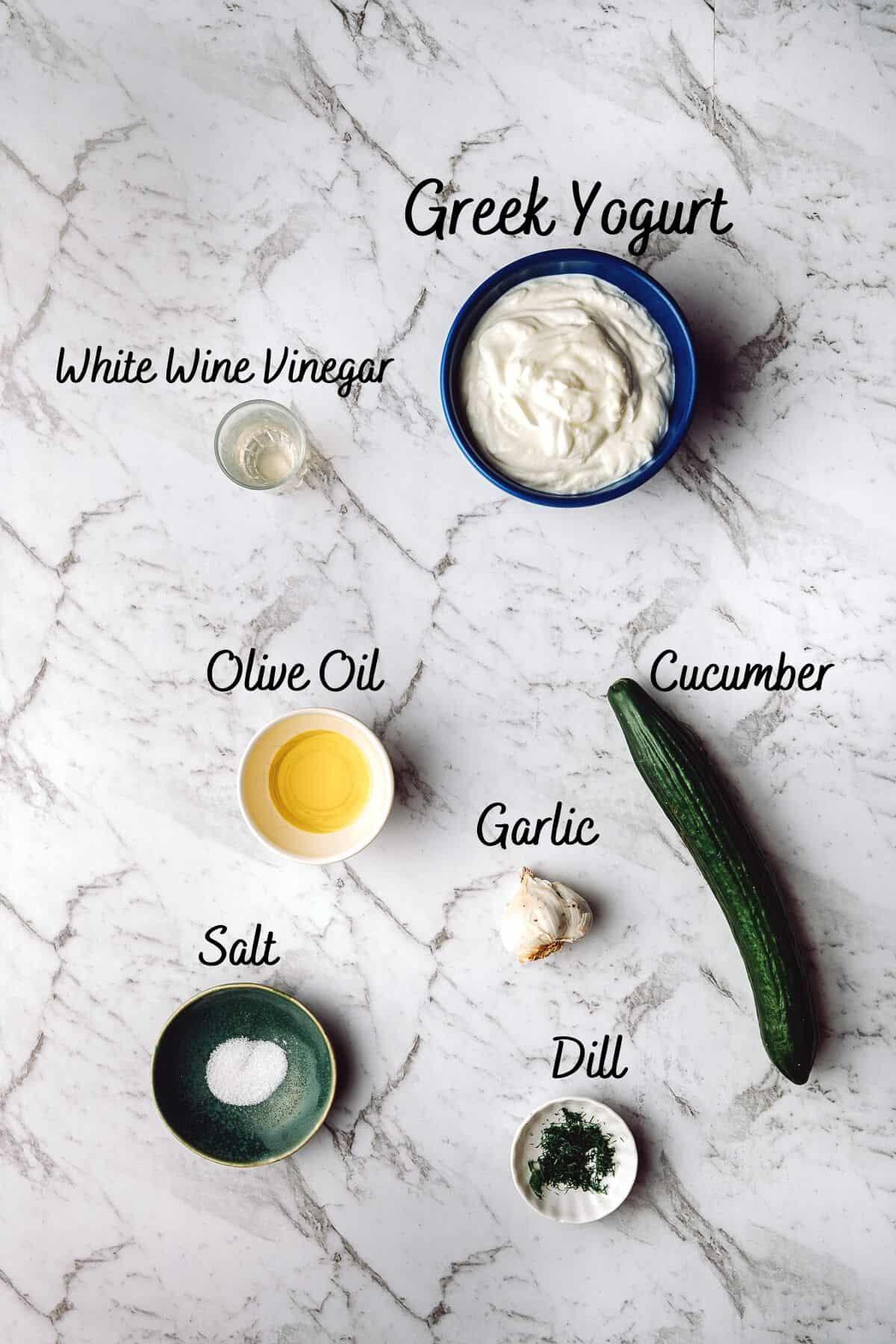 ingredients for tzatziki sauce laid out on a wooden table