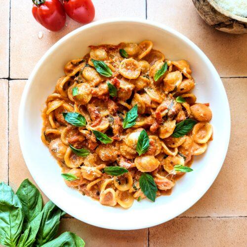 creamy tomato pasta in a bowl garnished with basil