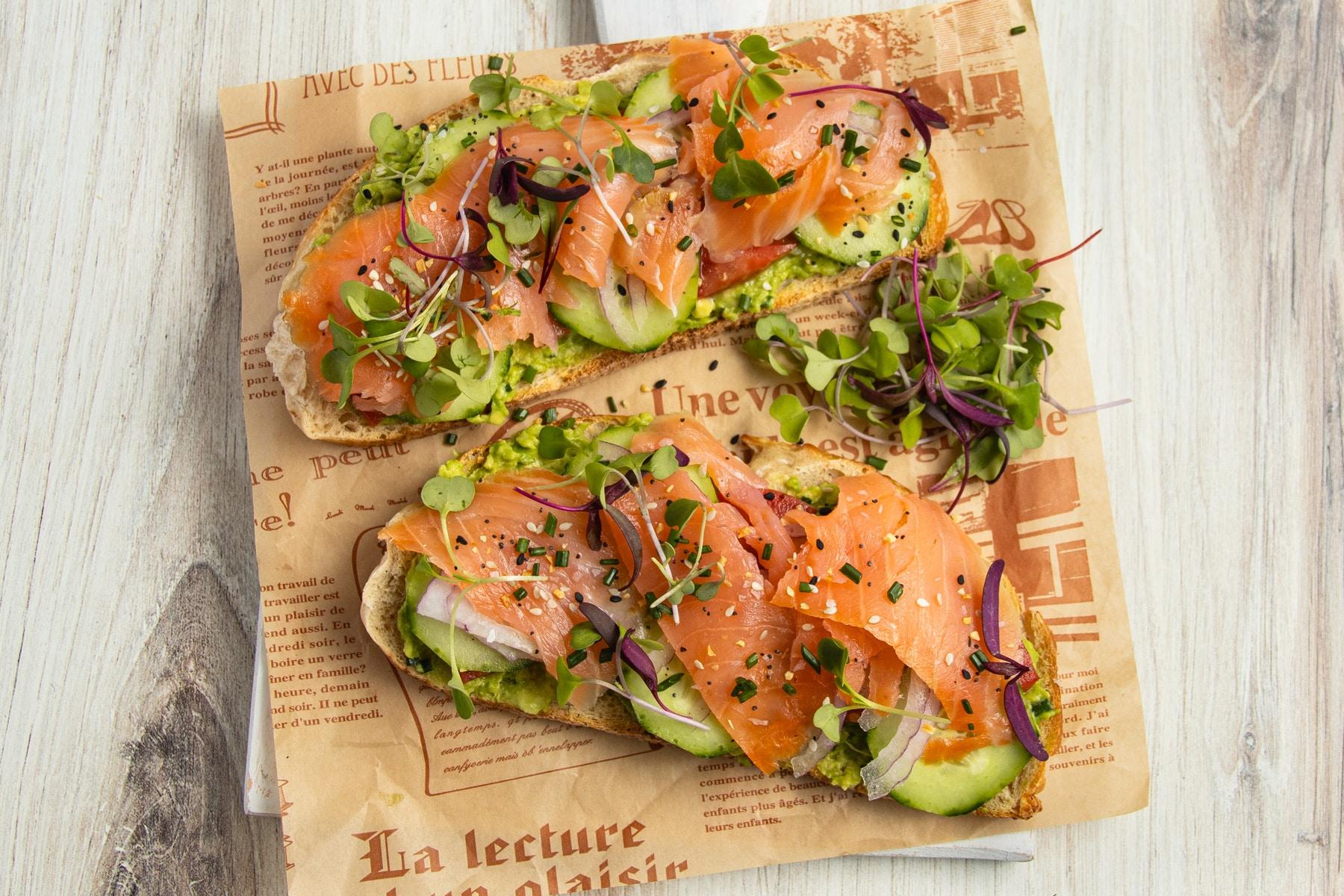 Ingredients for smoked salmon and avocado toast laid out on a wooden surface