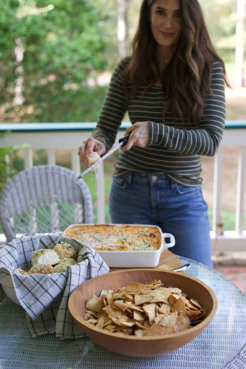 Guests enthusiastically serving themselves buffalo chicken dip at a lively outdoor party