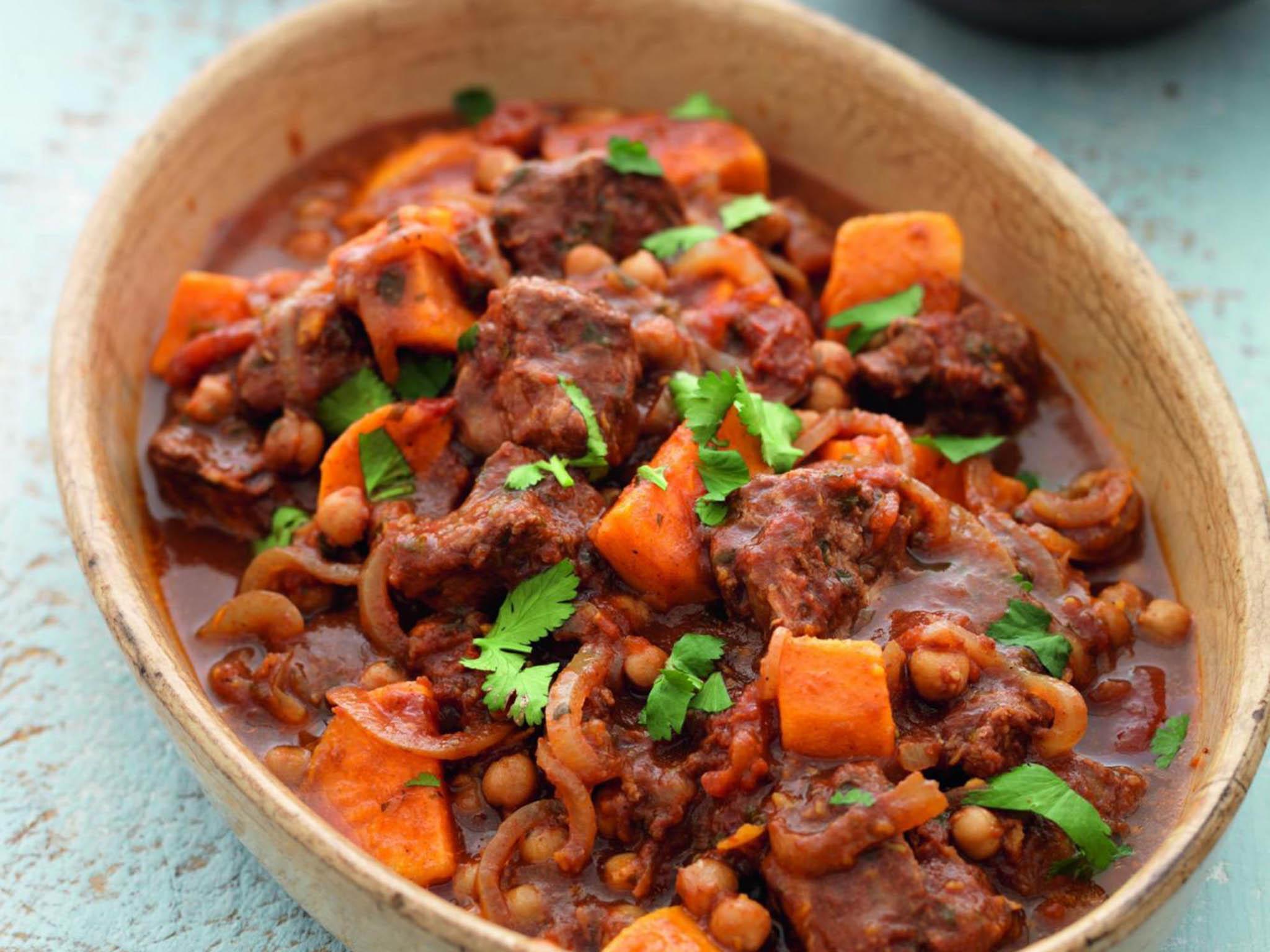 Close-up shot of lamb tagine with sweet potatoes and cranberries in a rustic Dutch oven