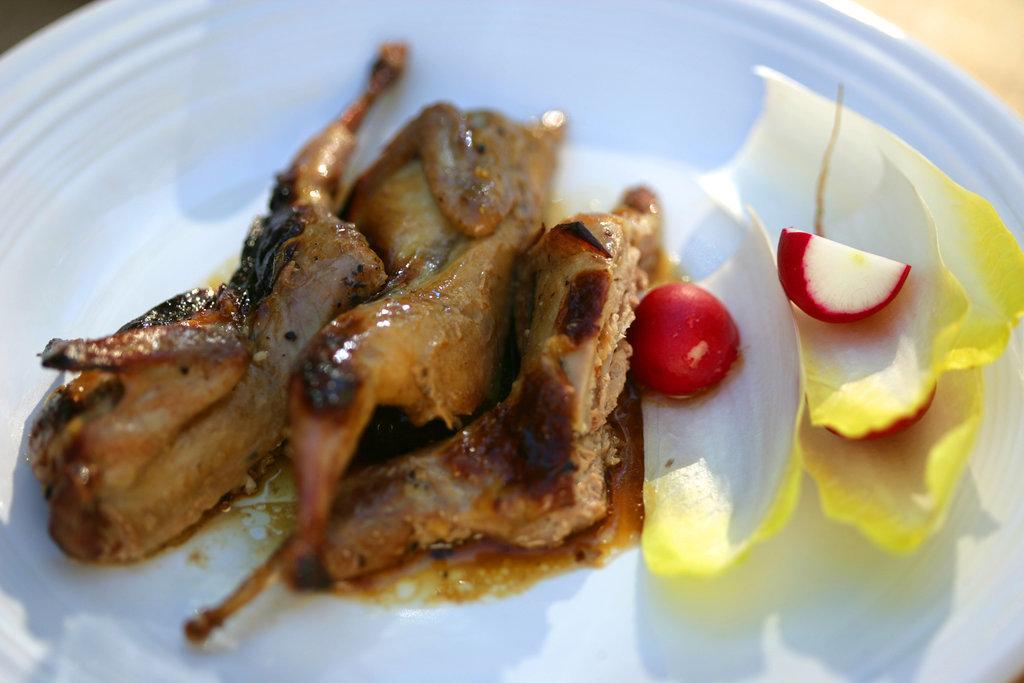 quail roasting in the oven, basting with pan juices
