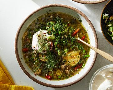 steaming bowl of citron and fennel soup garnished with fresh herbs