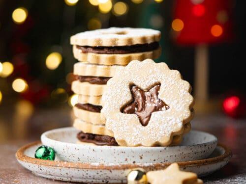 Espresso shortbread cookies on a vintage ceramic plate with a steaming latte, soft focus background