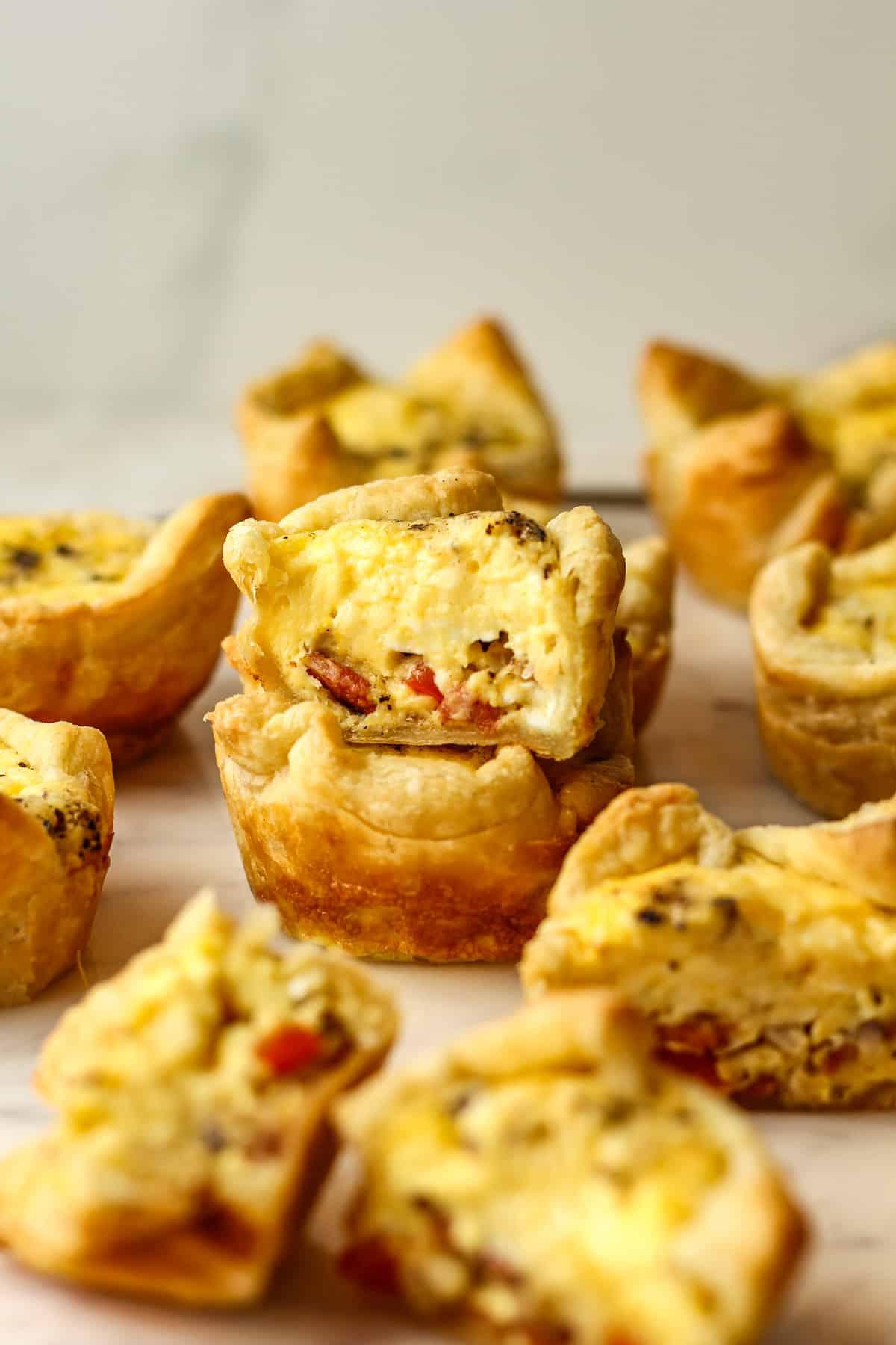 Hands gently placing mini cheese tarts into a hot oven, warm kitchen lighting