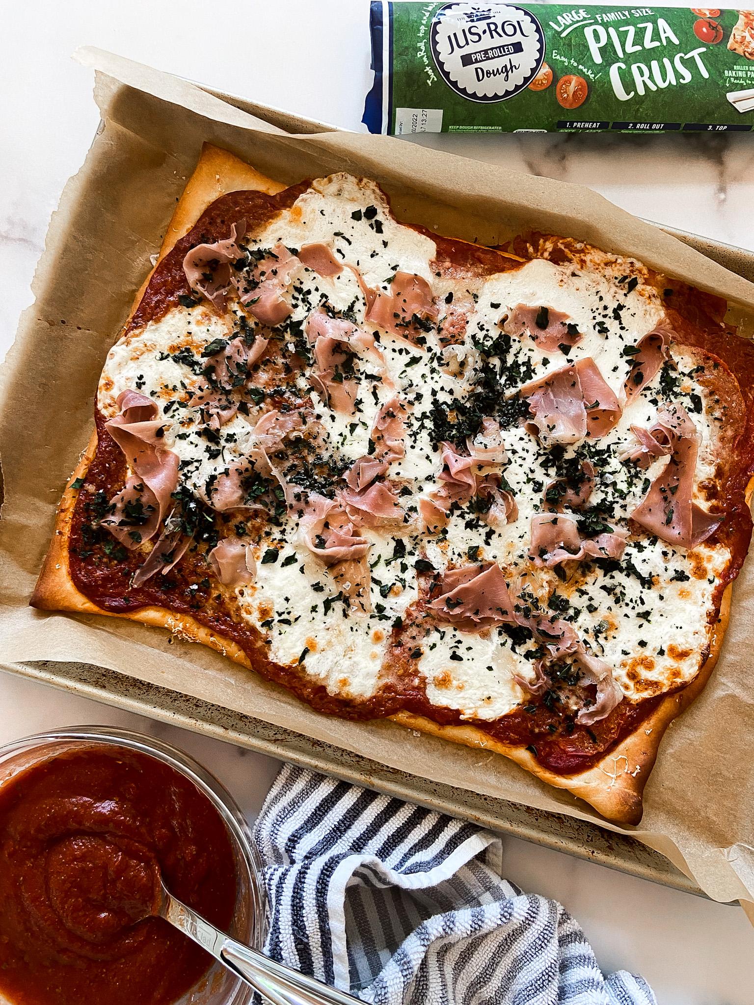rustic kitchen scene with ingredients for basil and prosciutto pizza rolls laid out